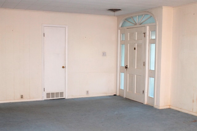 carpeted foyer with ornamental molding