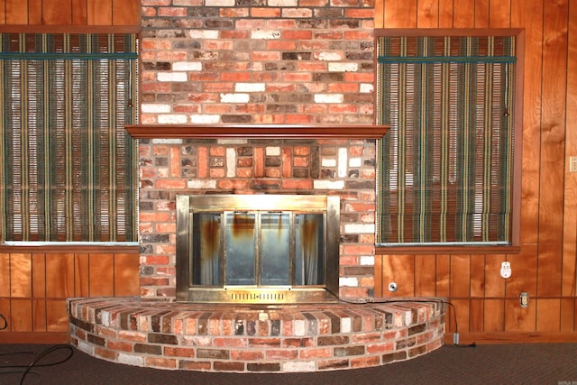 interior details featuring a fireplace and wood walls