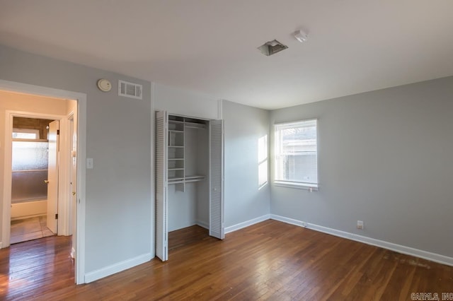 unfurnished bedroom featuring a closet and dark hardwood / wood-style flooring