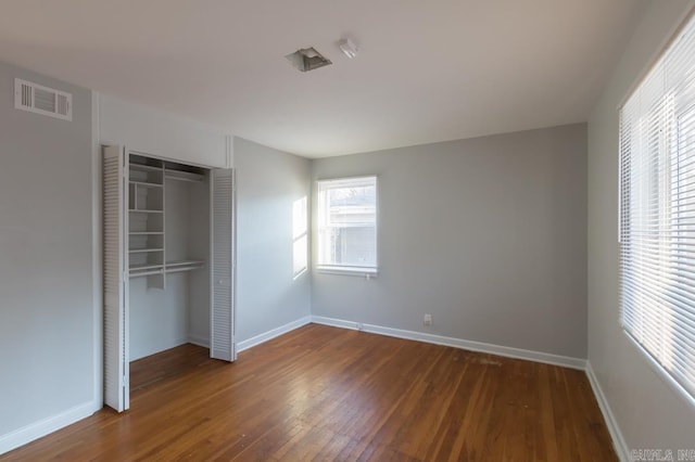 unfurnished bedroom with a closet and dark hardwood / wood-style floors