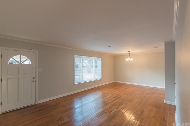 entryway with hardwood / wood-style floors, crown molding, and a chandelier