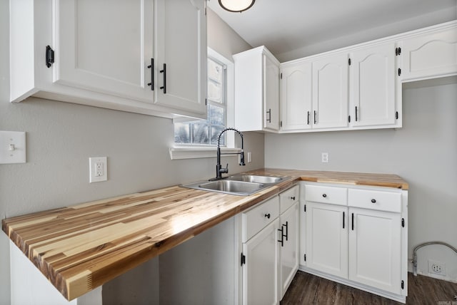 kitchen featuring sink, wooden counters, white cabinetry, and dark hardwood / wood-style floors