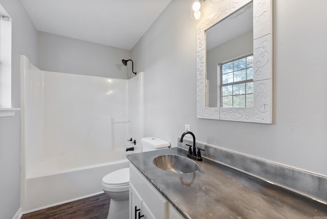 full bathroom featuring wood-type flooring, shower / washtub combination, vanity, and toilet