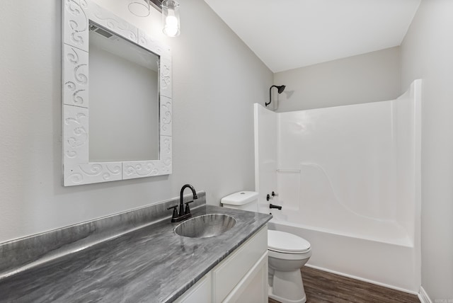 full bathroom with toilet, wood-type flooring, vanity, and shower / tub combination