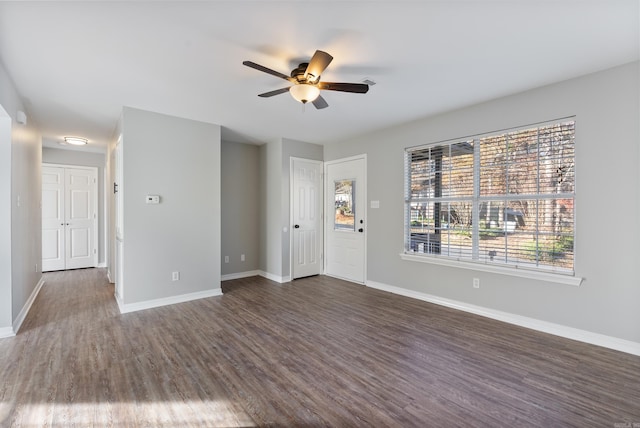 interior space with dark wood-type flooring, ceiling fan, and a wealth of natural light