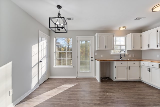 kitchen featuring sink, pendant lighting, white cabinetry, and hardwood / wood-style flooring