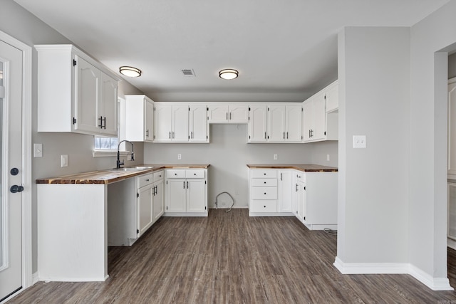 kitchen featuring sink, white cabinetry, butcher block countertops, and dark hardwood / wood-style floors