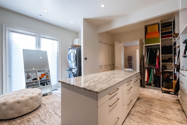 walk in closet with stacked washing maching and dryer