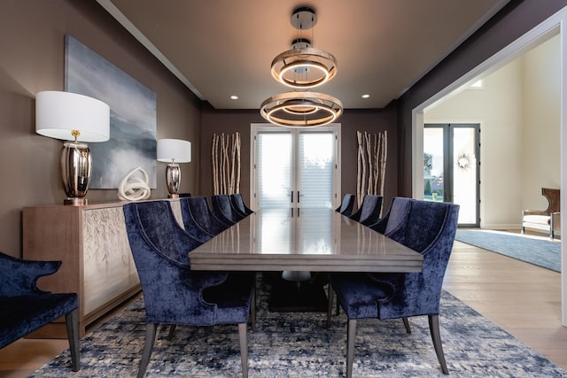 dining area featuring a notable chandelier, french doors, and hardwood / wood-style flooring