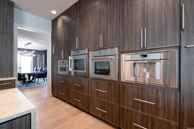 kitchen with light hardwood / wood-style floors and stainless steel oven