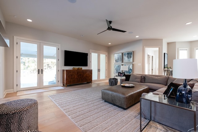 living room featuring ceiling fan, french doors, and light hardwood / wood-style floors