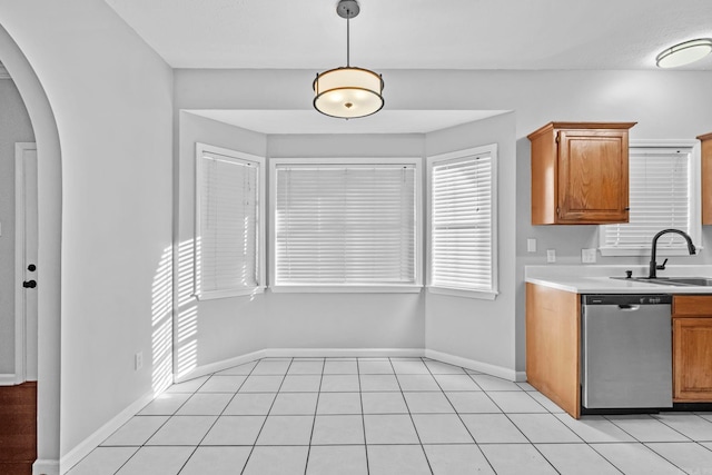 kitchen with light tile patterned flooring, dishwasher, sink, and hanging light fixtures