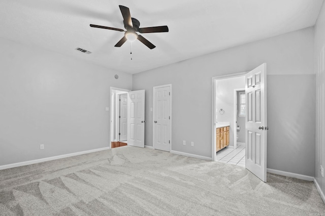 unfurnished bedroom featuring connected bathroom, light colored carpet, and ceiling fan