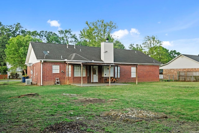 rear view of house with a patio, cooling unit, and a lawn