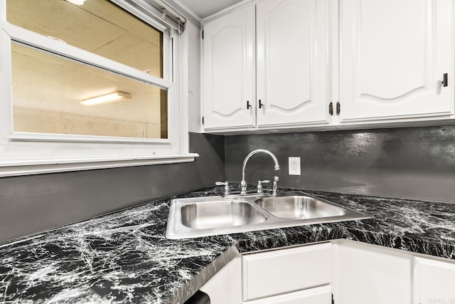 kitchen featuring white cabinets and sink