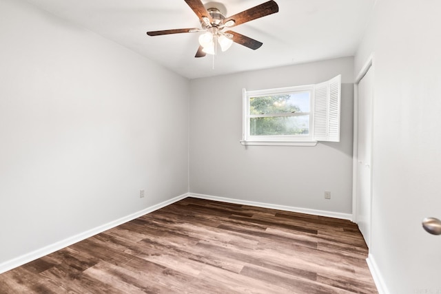 empty room featuring dark hardwood / wood-style flooring and ceiling fan