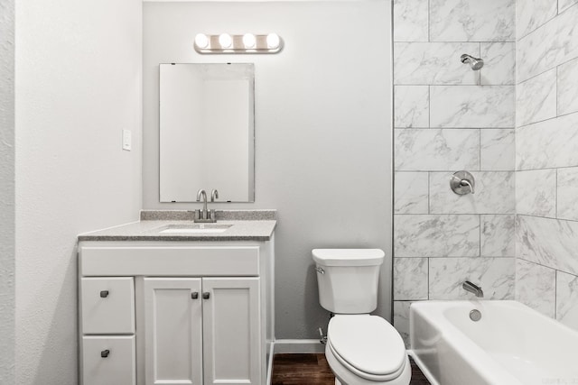 full bathroom with tiled shower / bath, vanity, and toilet