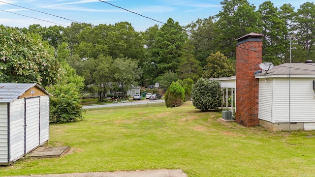 view of yard featuring a storage unit and central air condition unit