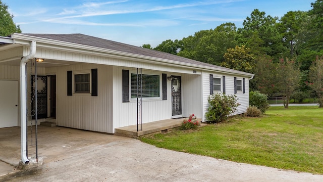 view of front of house with a carport and a front lawn