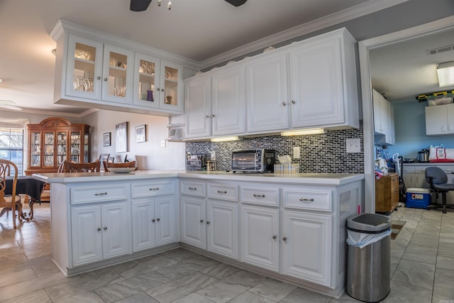 kitchen with kitchen peninsula, ceiling fan, and white cabinetry