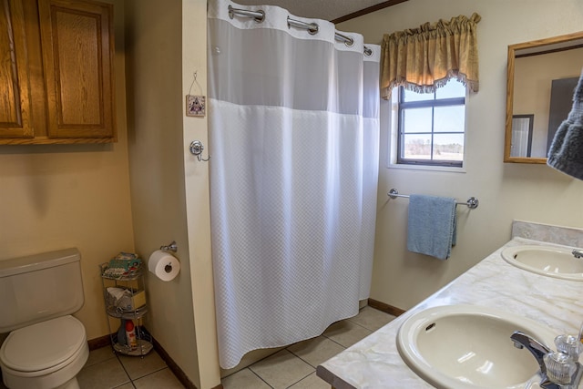 bathroom with tile patterned floors, toilet, double vanity, and a sink