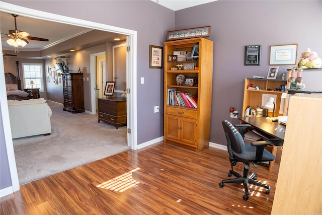 office area featuring wood finished floors, ceiling fan, crown molding, and baseboards