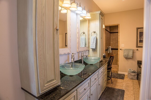 bathroom with walk in shower, double vanity, a sink, and tile patterned floors