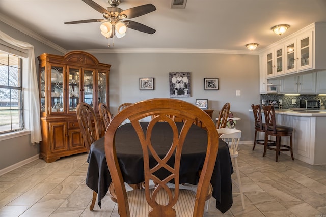 dining room with ornamental molding and ceiling fan