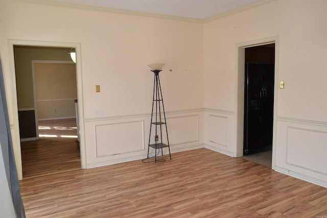 unfurnished room with ornamental molding and hardwood / wood-style floors