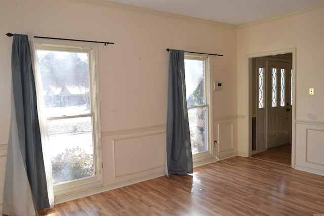 foyer featuring light wood-type flooring and crown molding