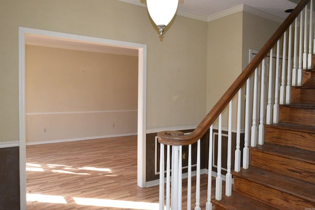 staircase with hardwood / wood-style floors and ornamental molding