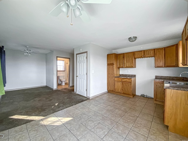 kitchen with ceiling fan, sink, and light colored carpet