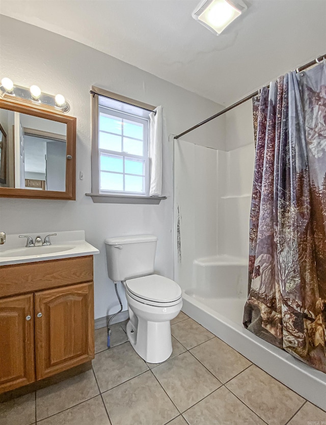 bathroom featuring toilet, vanity, a shower with curtain, and tile patterned floors