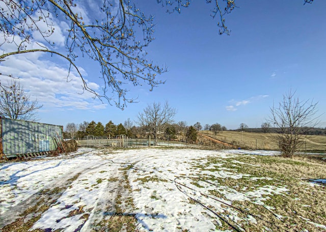 snowy yard featuring a rural view