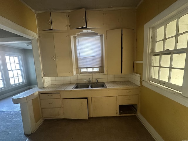 kitchen with sink, tile countertops, and cream cabinets