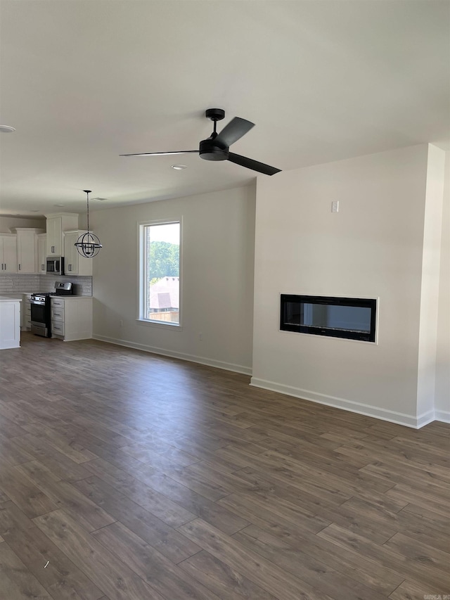 unfurnished living room featuring ceiling fan and dark wood-type flooring