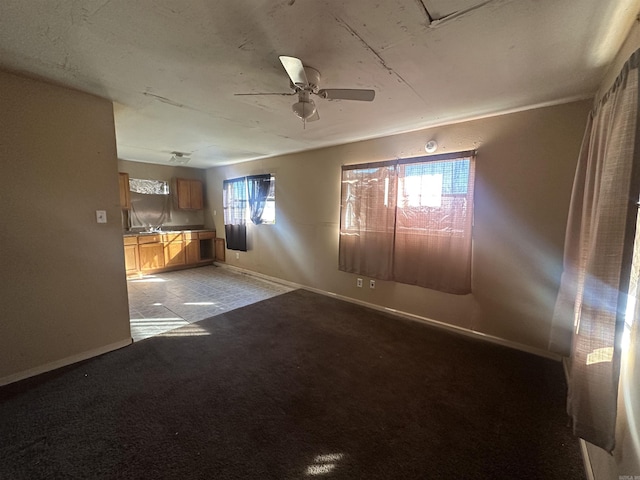 carpeted spare room with ceiling fan and plenty of natural light