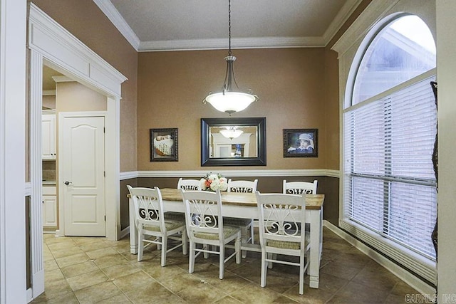 dining space featuring ornamental molding and light tile patterned floors