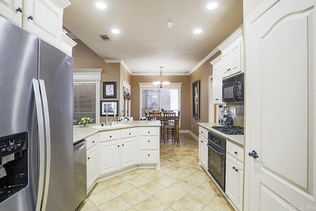 kitchen featuring sink, decorative light fixtures, white cabinetry, a chandelier, and black appliances