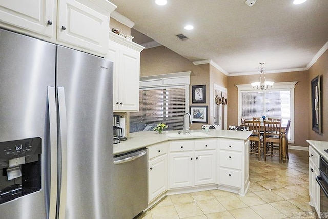 kitchen featuring a chandelier, stainless steel appliances, hanging light fixtures, white cabinets, and sink