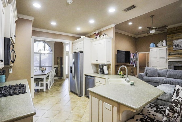 kitchen with a kitchen bar, white cabinetry, appliances with stainless steel finishes, ceiling fan, and sink