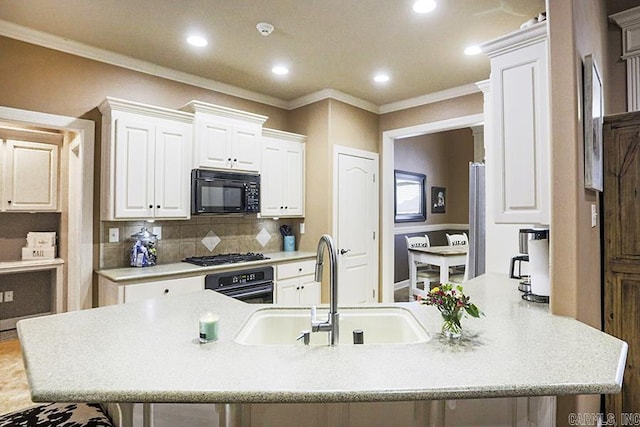 kitchen featuring sink, white cabinets, a kitchen breakfast bar, and black appliances