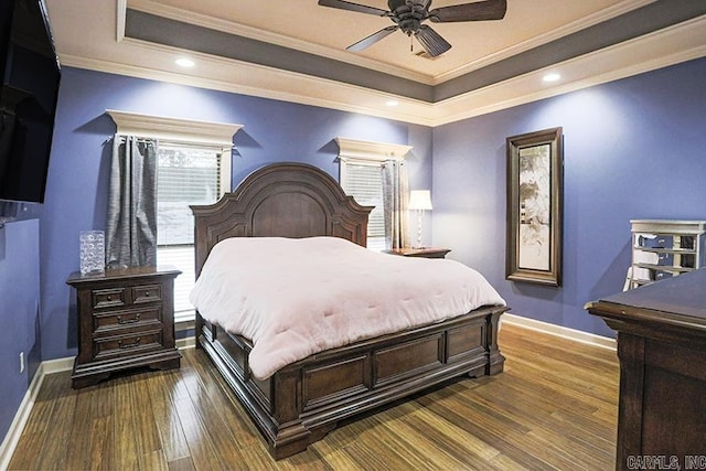 bedroom with dark wood-type flooring, a raised ceiling, ceiling fan, and ornamental molding