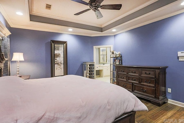 bedroom featuring ensuite bath, ceiling fan, a tray ceiling, and crown molding