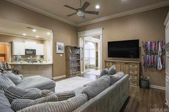 living room with sink, ornamental molding, ceiling fan, and dark wood-type flooring