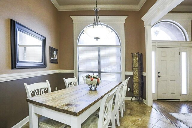 dining area with tile patterned floors and ornamental molding