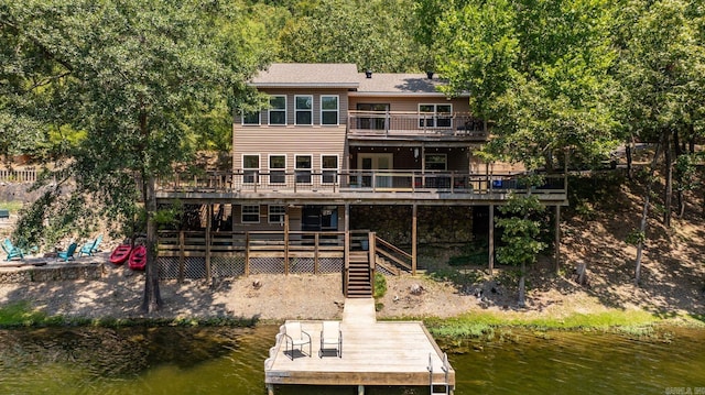 rear view of house with a balcony and a deck with water view