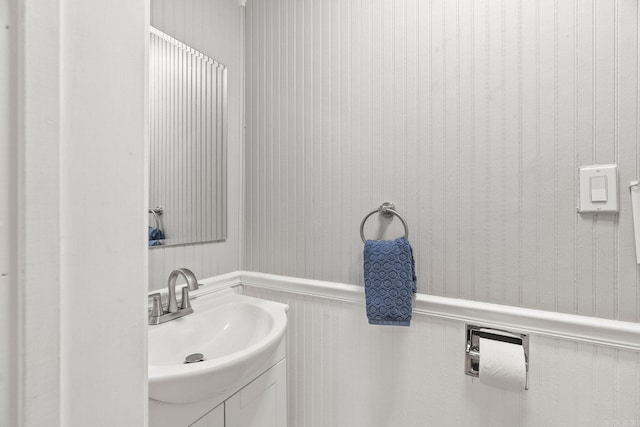 bathroom with wooden walls and sink