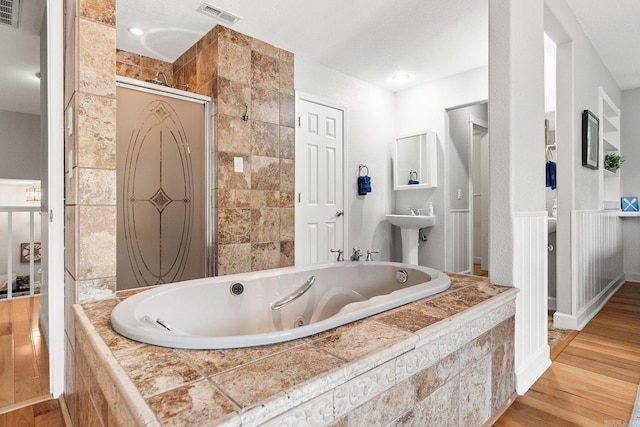 bathroom featuring sink, hardwood / wood-style floors, and independent shower and bath