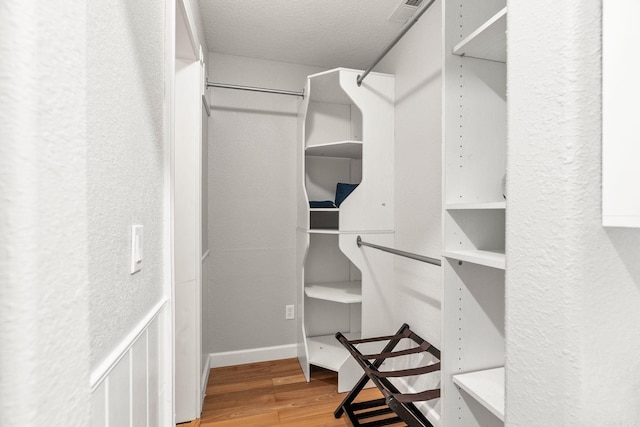 spacious closet with hardwood / wood-style flooring